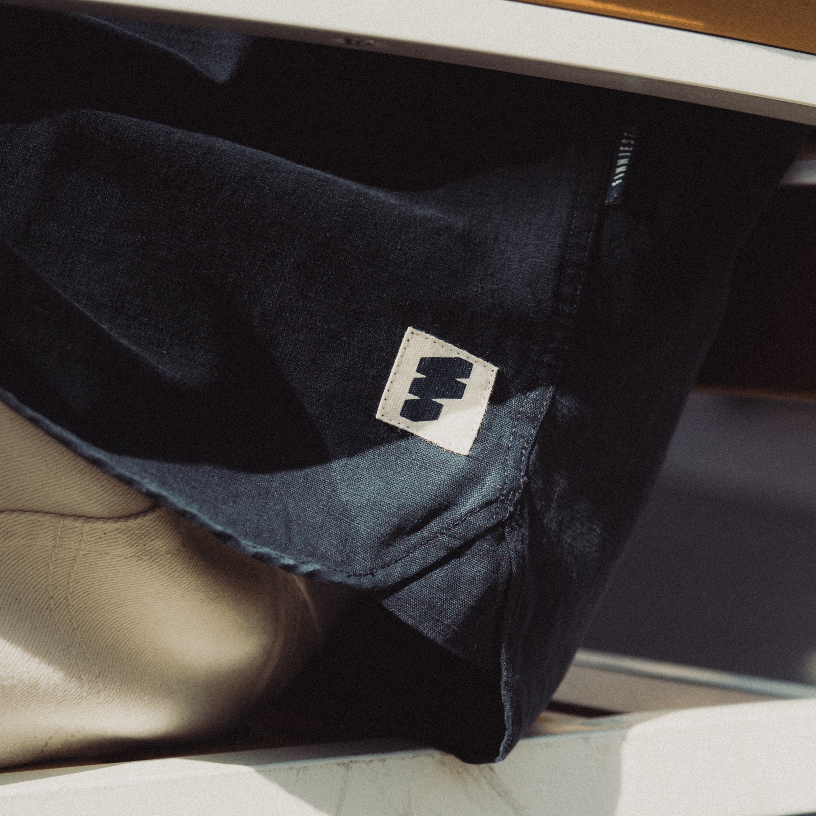 Dark blue jacket with a logo on a reflective surface