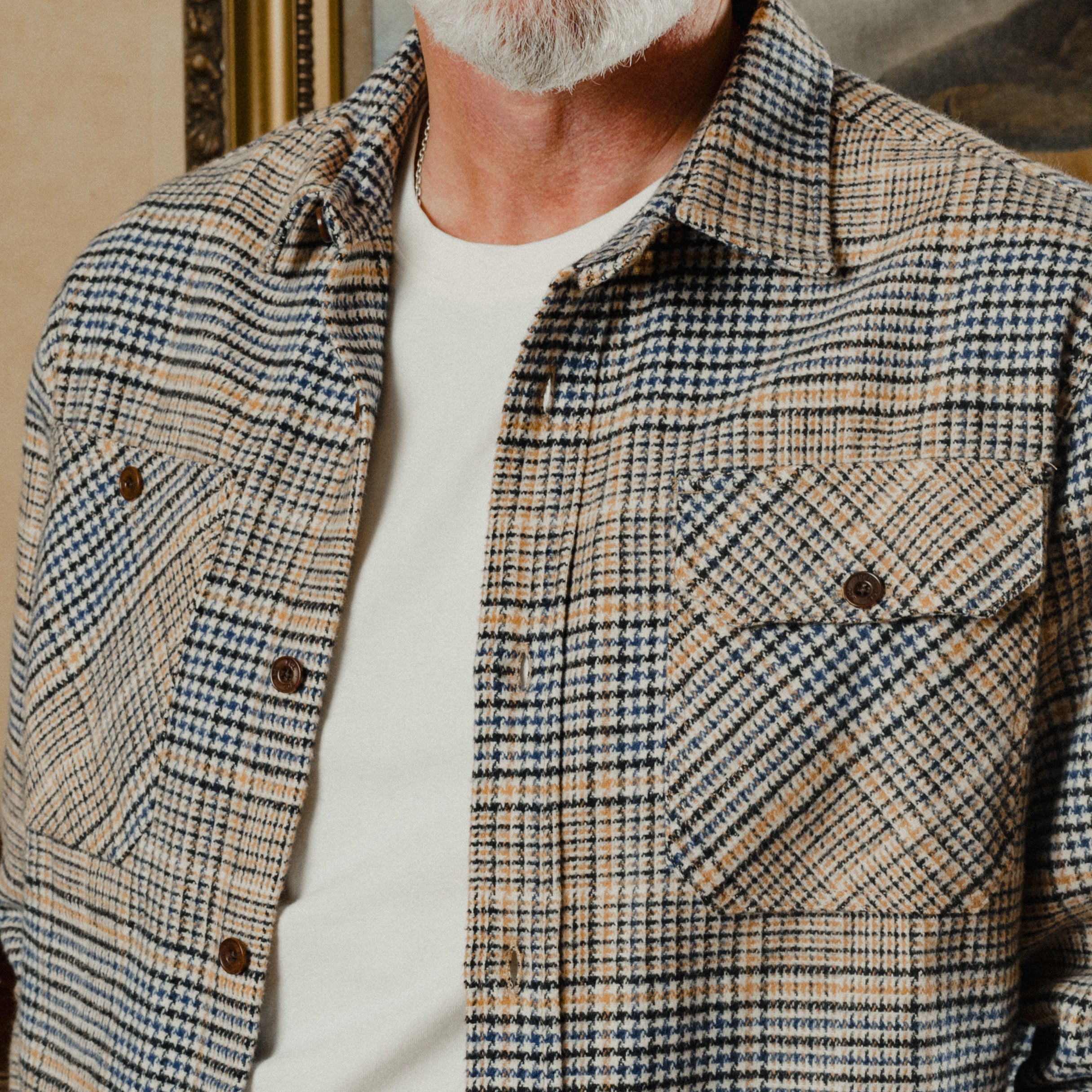 Man wearing a plaid shirt with a neutral background
