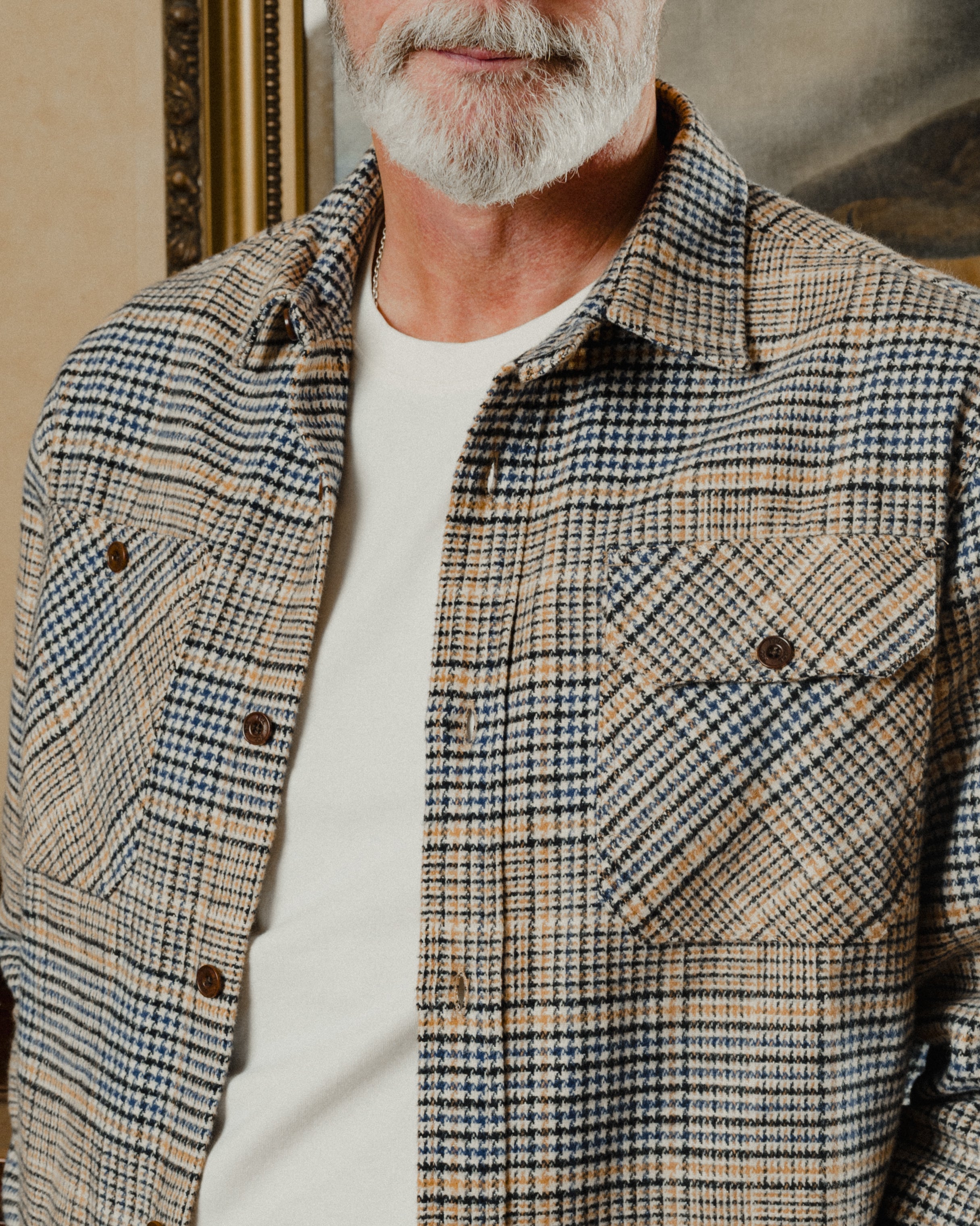 Man wearing a plaid shirt with a neutral background