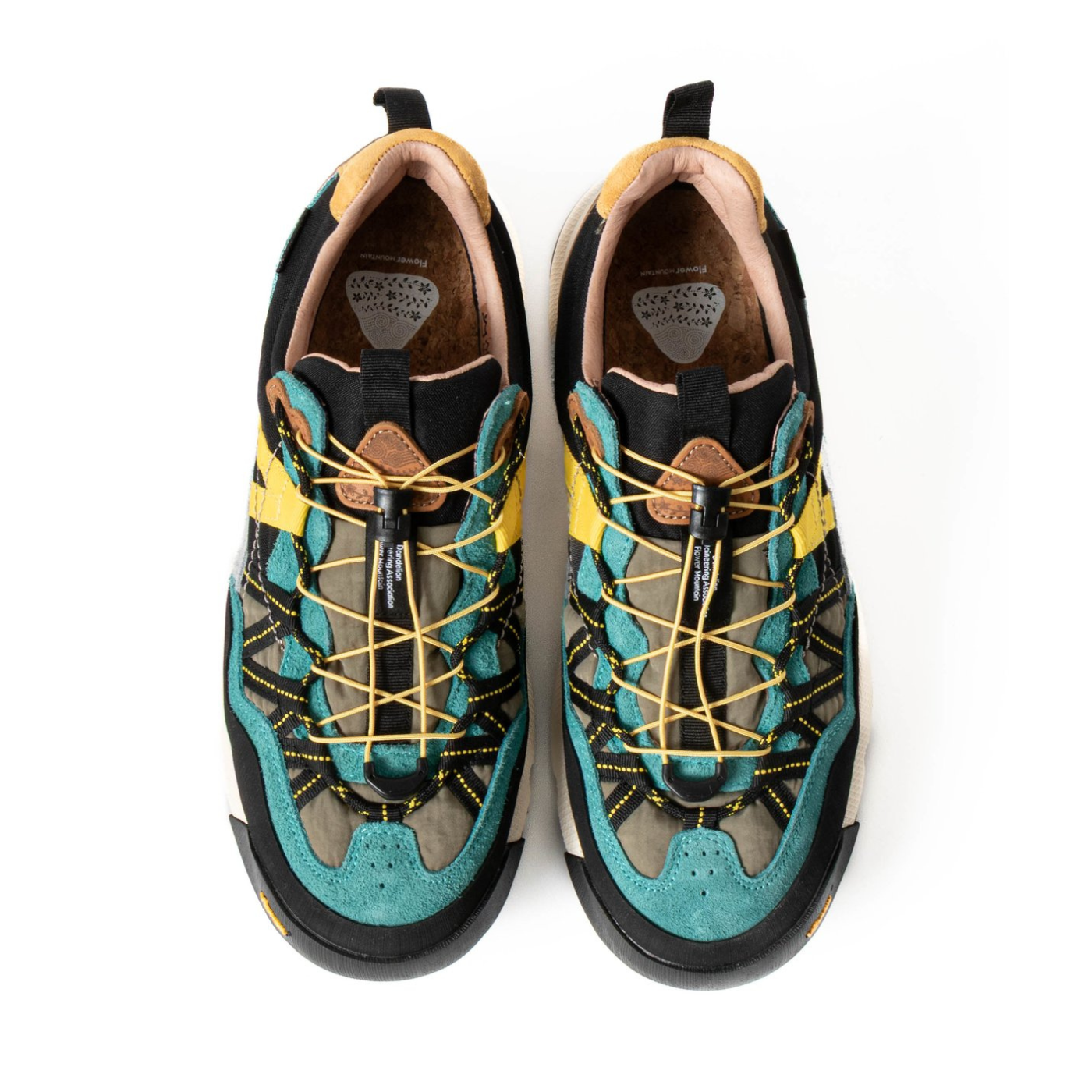 Flower Mountain Pair of teal and black sneakers with yellow laces on a white background