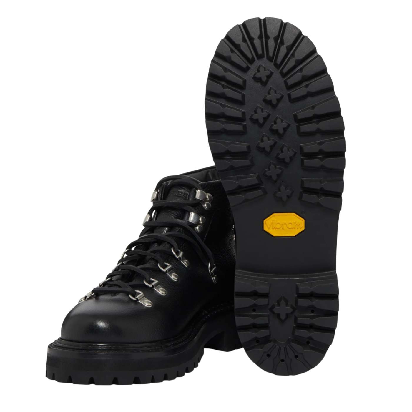 Black boots with yellow label on sole against a white background