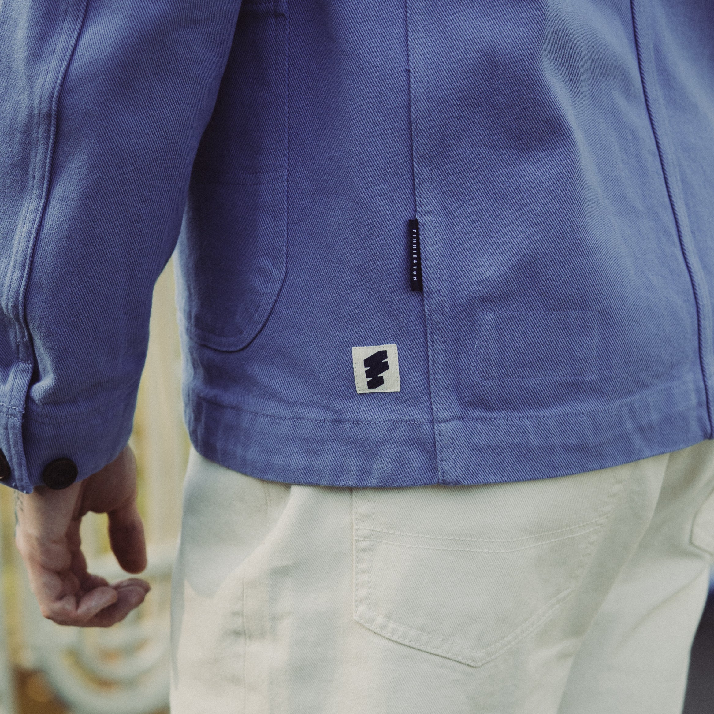 Close-up of a blue jacket with a brand logo on a blurred background