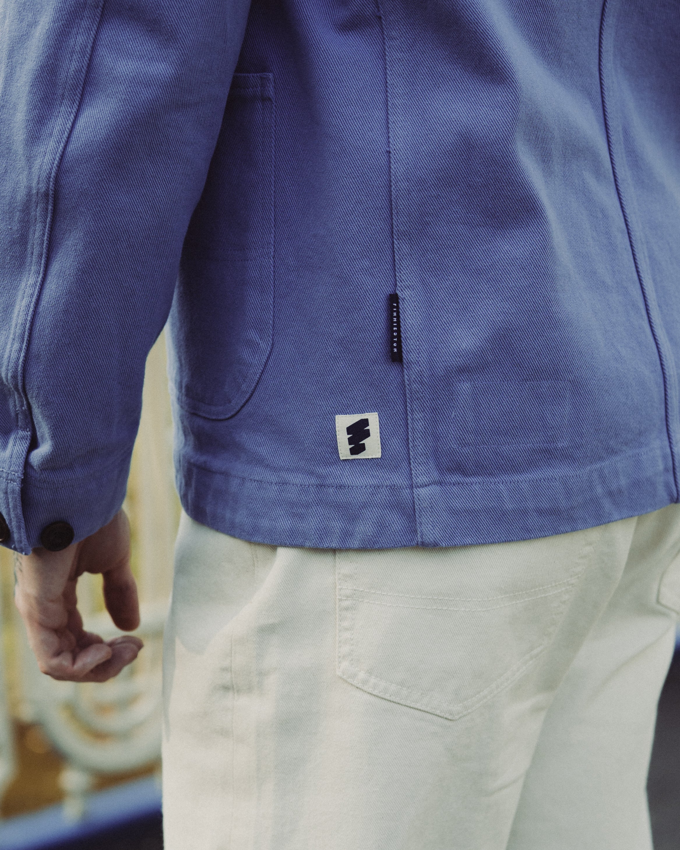 Close-up of a blue jacket with a brand logo on a blurred background