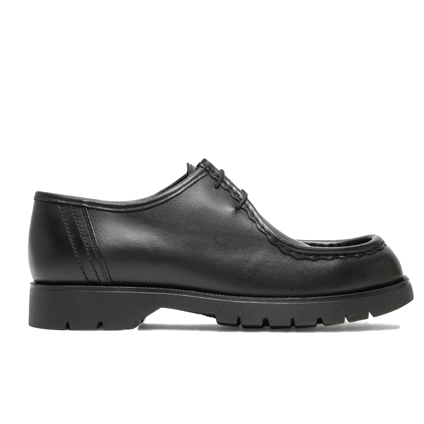 A pair of black, cowhide leather shoes with a serrated hem and fancy stitching, featuring a durable rubber outsole and tonal wax laces.