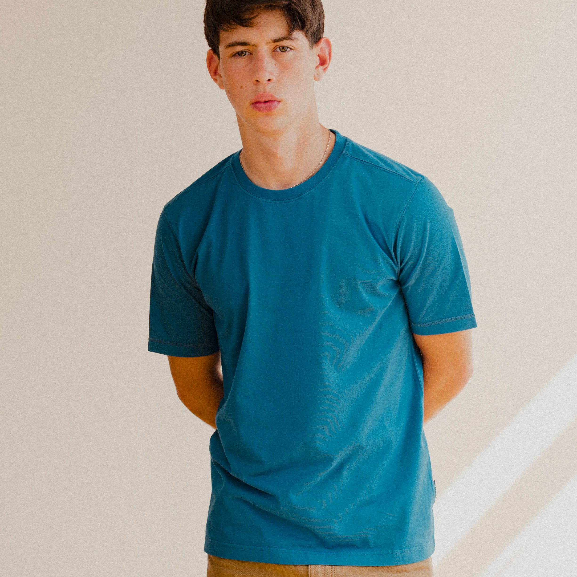 Man wearing a blue t-shirt against a plain background