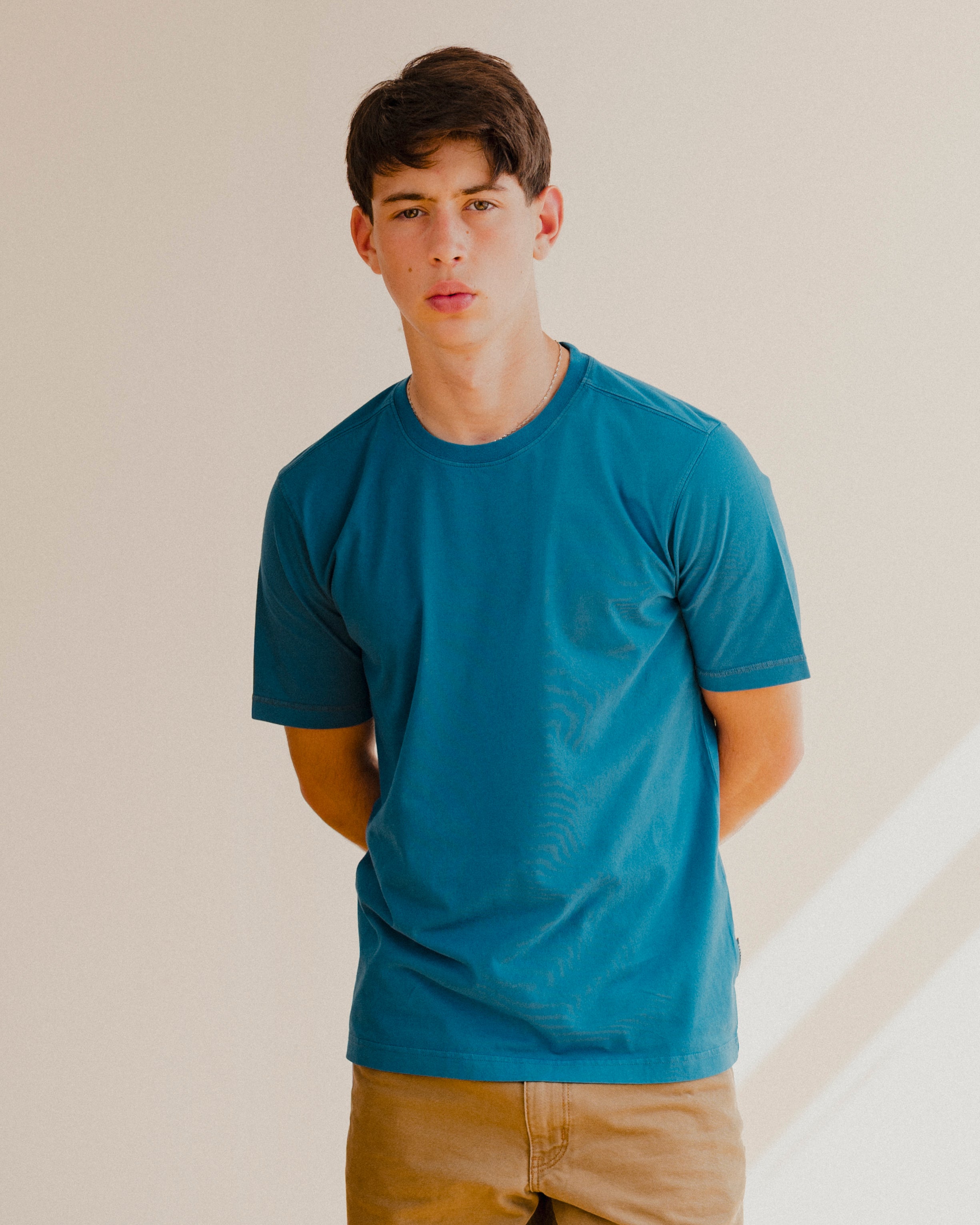 Man wearing a blue t-shirt against a plain background