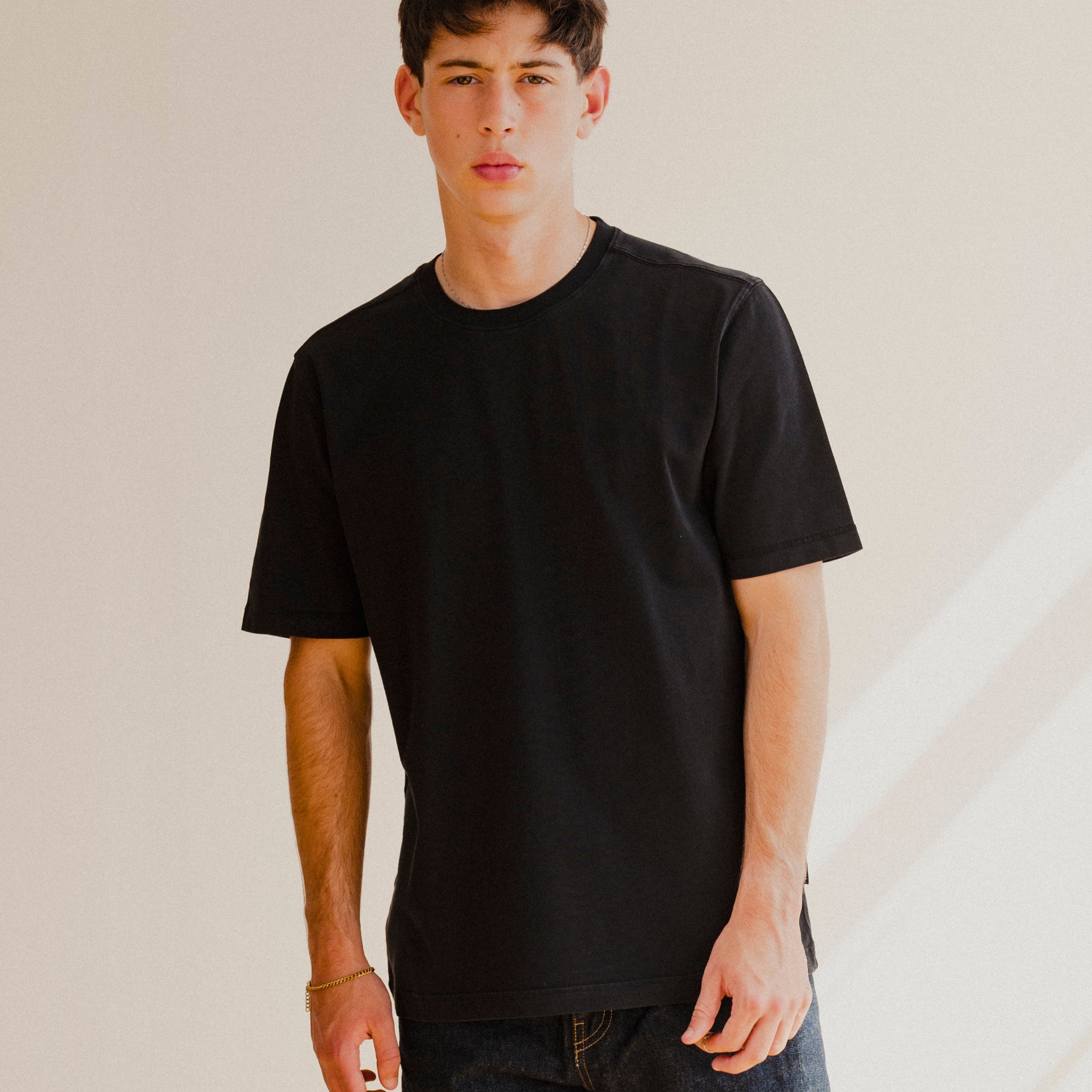 Person wearing a black t-shirt against a plain background