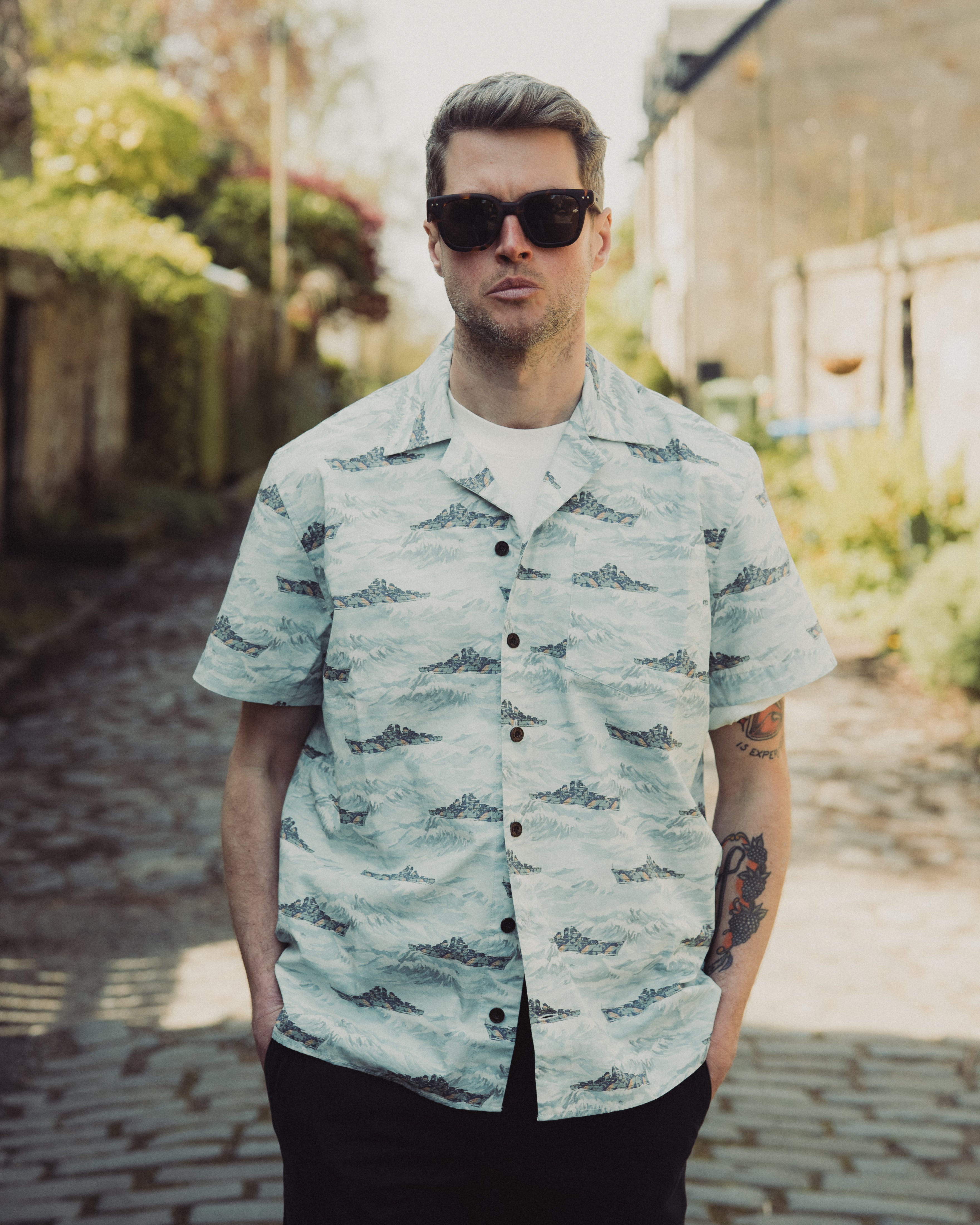 Man wearing a patterned shirt and sunglasses outdoors