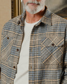 Man wearing a plaid shirt with a neutral background