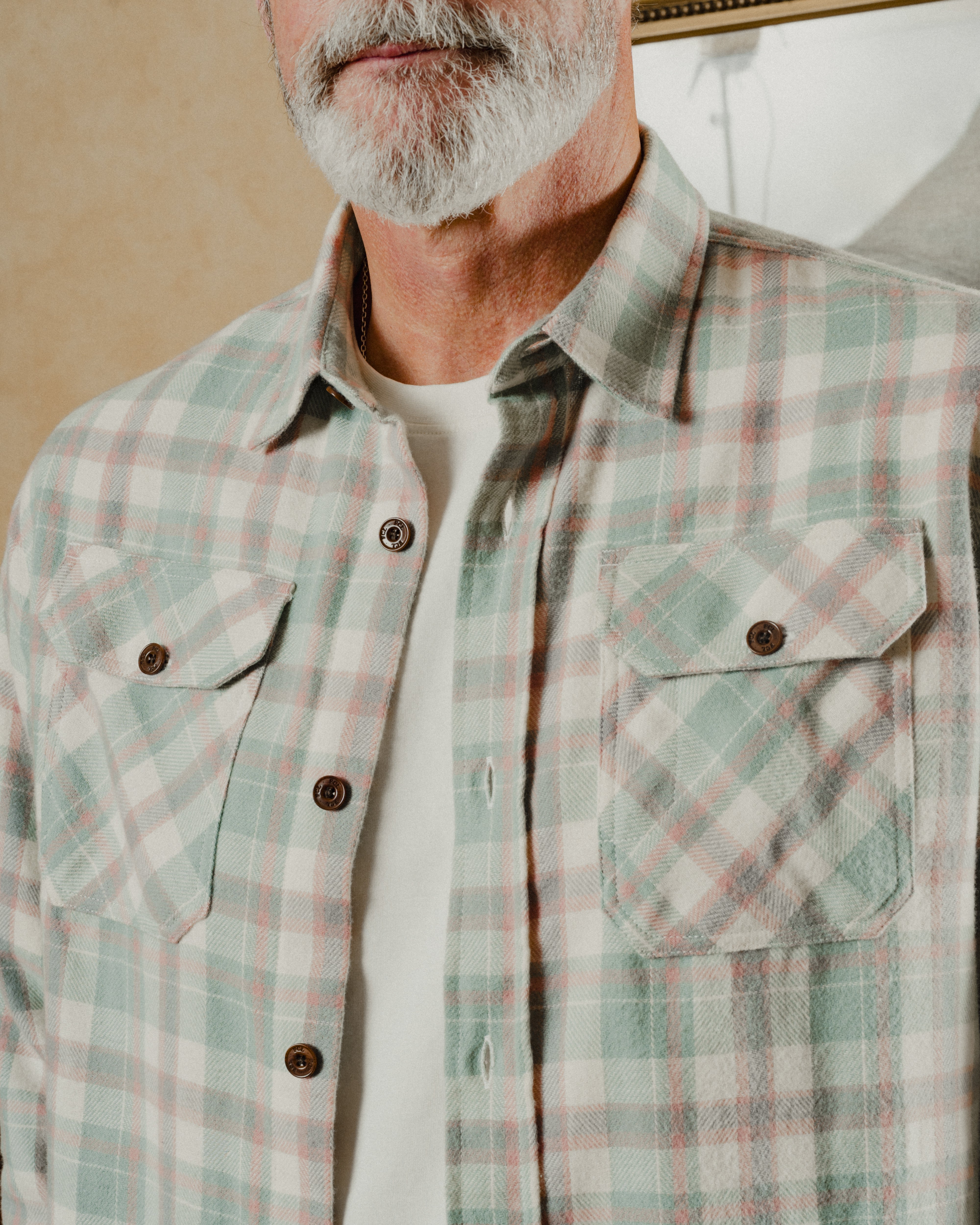 Man wearing a plaid shirt with a neutral background