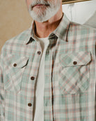 Man wearing a plaid shirt with a neutral background