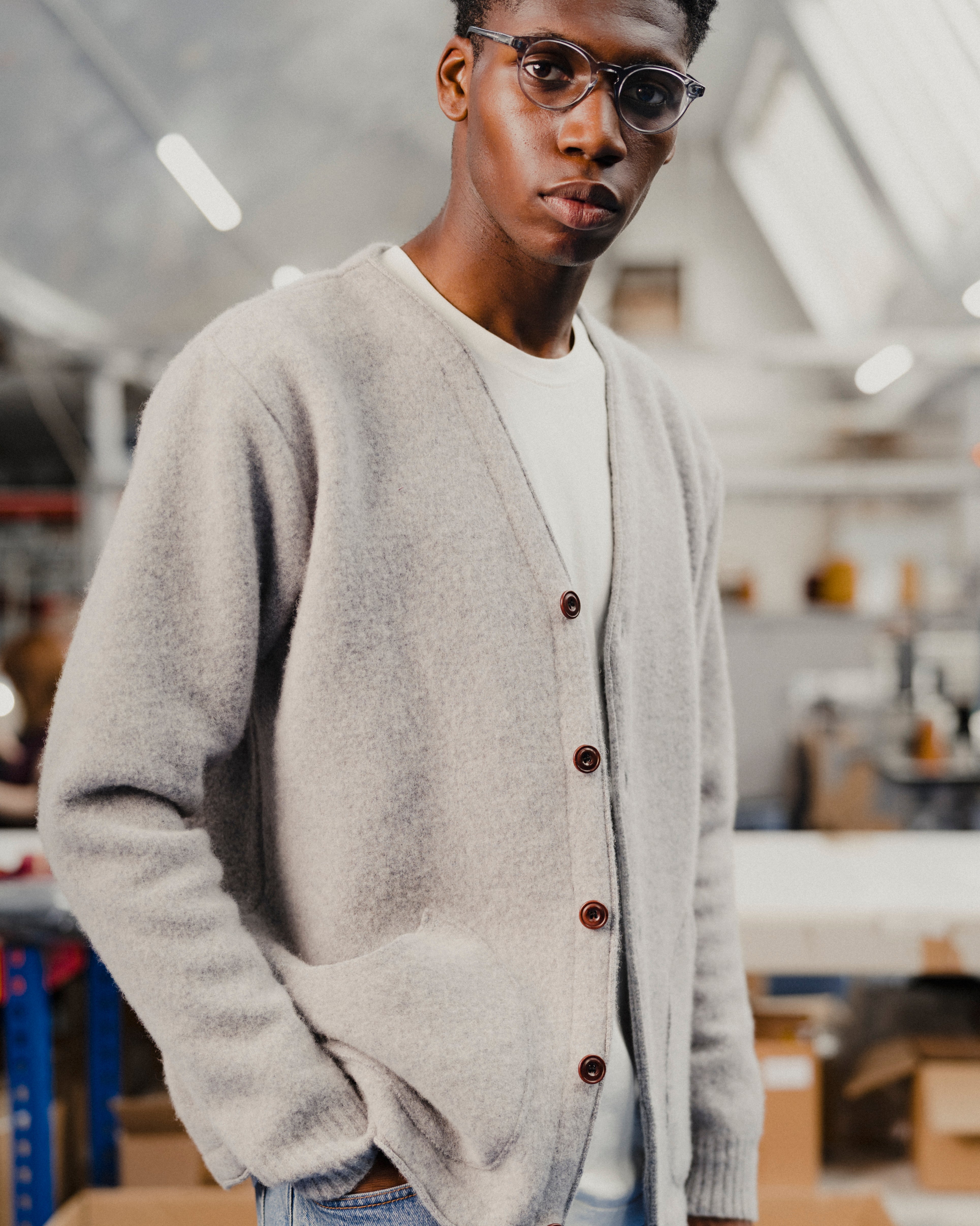 Person wearing a gray cardigan with brown buttons in an indoor setting