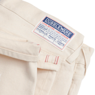 Beige jeans with a 'Dubbleware' label on a white background