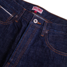 Close-up of blue jeans with a visible brand label on a white background