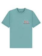 A light teal short-sleeve crewneck t-shirt with a small red and white graphic on the left chest reading 'FCL BUILT TOGETHER'. The brand name 'FINNIESTON' is visible printed inside the collar.