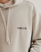 grey hoodie with 'FINNIESTON' text on a plain background