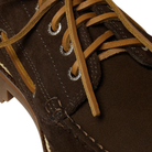 Close-up of a brown leather shoe with laces on a white background