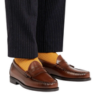 Brown loafers with black dress pants and yellow socks on a white background