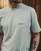 Person wearing a light green t-shirt with 'John Brown & Company Ltd' logo.
