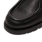 Close-up of a black leather shoe on a white background