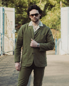 Man wearing a green jacket and sunglasses outdoors