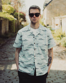 Man wearing a patterned shirt and sunglasses outdoors