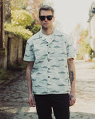 Man wearing a patterned shirt and sunglasses outdoors