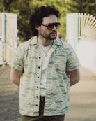 Man wearing a patterned shirt and sunglasses outdoors