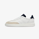 White sneaker with navy accents on a light beige background