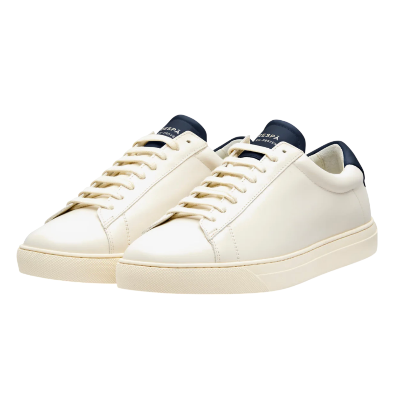 Pair of white sneakers with navy accents on a white background