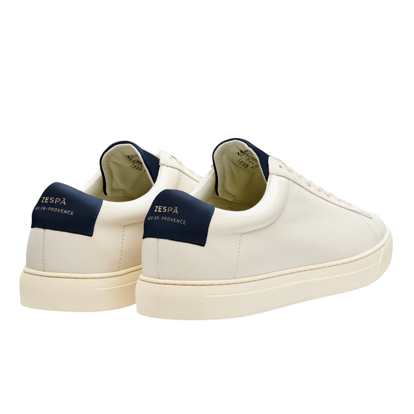 White sneakers with navy accents on a white background